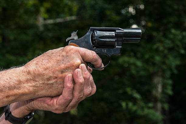 Hands aiming a pistol Caucasian senior hands holding and aiming a pistol handgun old guns stock pictures, royalty-free photos & images