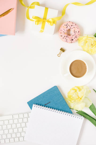 istock Notebook for daily planning with breakfast serving on a white background, a cup of coffee, a donut, flowers and a gift box with a bow. The concept of daily planning of life, work, study. Mother's Day or Easter. Copy space 1862555953
