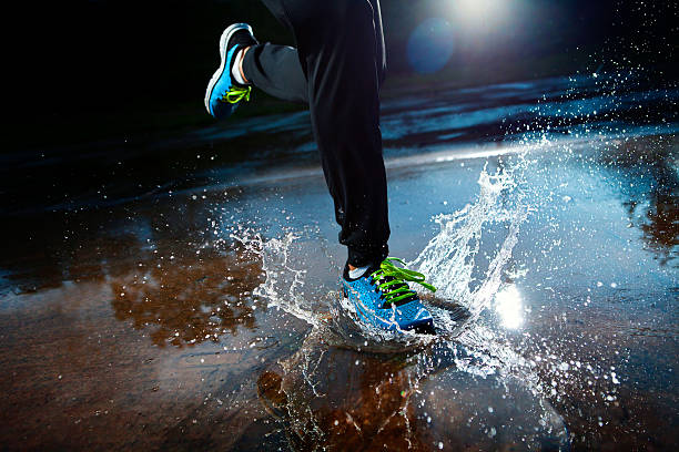 Athlete running in the rain stock photo