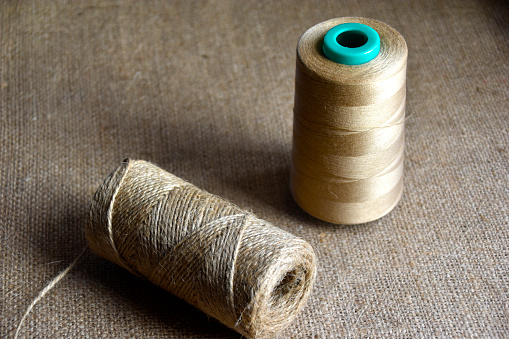 Skeins of thread on burlap. Yellow threads on coarse cloth.