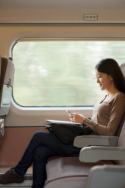 istock Young woman sitting on a train using her phone 186262684