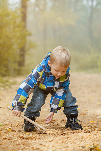 istock Image of cheerful boy playing in autumn park 186264239
