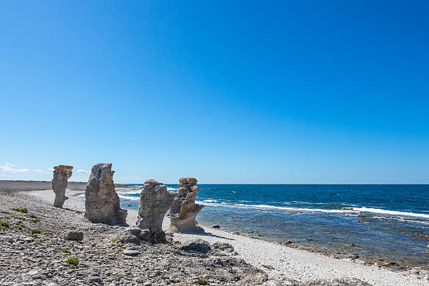 cliff formações rochosas na costa rochosa de gotland, suécia - stack rock fotos - fotografias e filmes do acervo