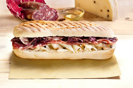 Typical Italian sandwich with salami, fresh pepato cheese, and lettuce