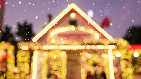 Beautiful blurred of house decorated for Christmas. Christmas lights on house and snowy. Christmas atmosphere. Snow falling on Christmas day. Home decoration lights