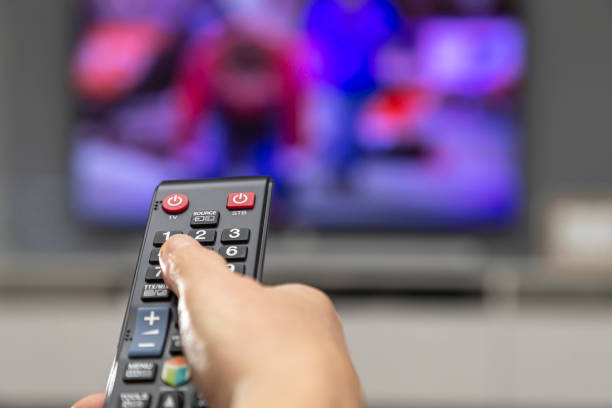istock A woman's hand with a remote control switches channels on the TV. 1862672159