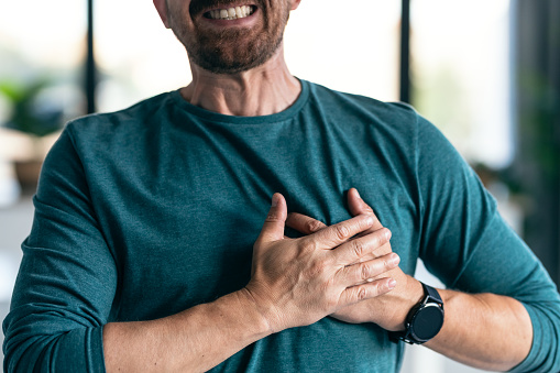 Shot of mature man having a heart attack after receiving bad news while at home