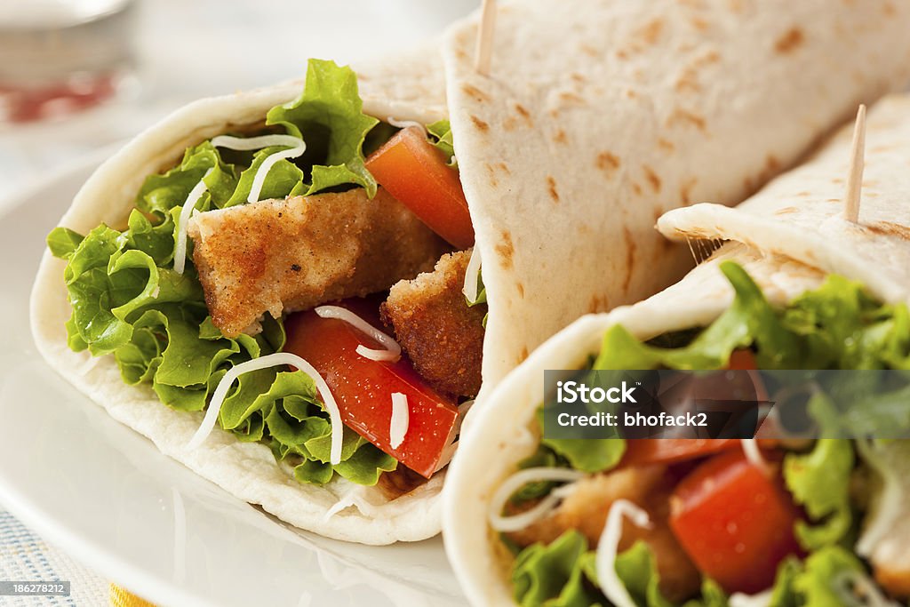 Breaded Chicken in a Tortilla Wrap Breaded Chicken in a Tortilla Wrap with Lettuce and Tomato Appetizer Stock Photo