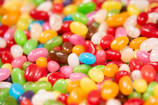 candy coated with rainbow-colored chocolates on the front and white background