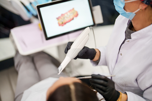 Dentist using a dental scanner for patients teeth