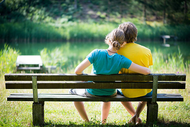 istock lovely young couple sitting on seat bench 186281808