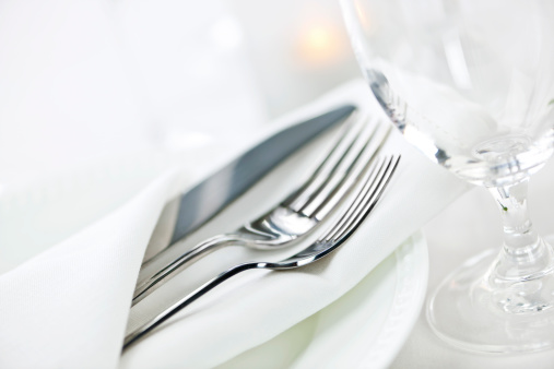 Elegant restaurant table setting for fine dining with plates cutlery and stemware