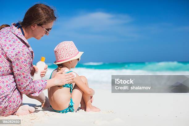 Mother Putting Sunscreen In Her Child On The Beach Stock Photo - Download Image Now - Suntan Lotion, Child, Family