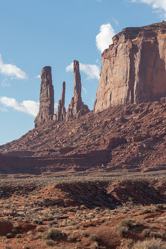 Tall spires and mesas of rich dark red rugged mountains near Monument Valley in Arizona and Utah of western USA in North America. This is part of the Navajo Nation in USA.  Nearest cities are Phoenix, Arizona, Salt Lake City, Utah, Denver and Durango, Colorado.