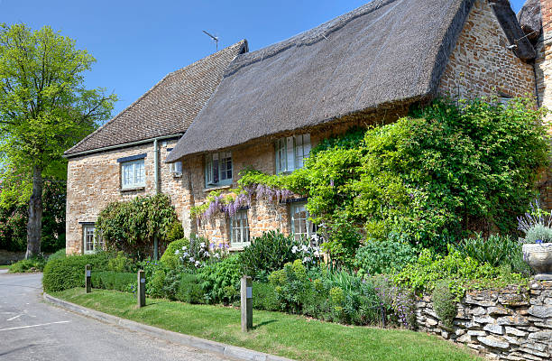 Thatched cottage at Kingham Thatched cottage with pretty garden, Kingham, Oxfordshire, England. oxfordshire stock pictures, royalty-free photos & images