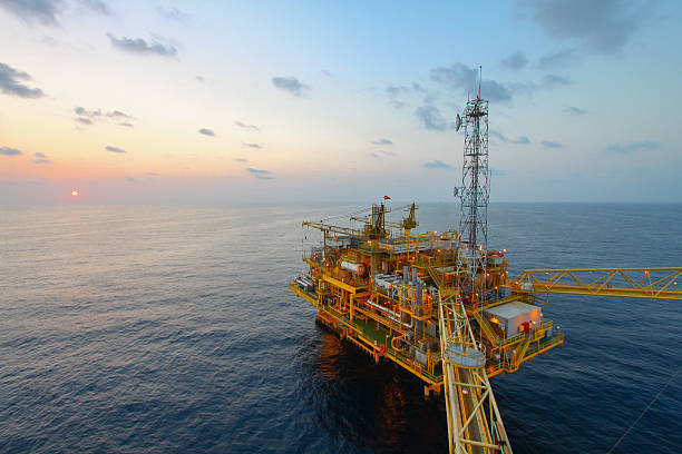 piattaforma petrolifera e del gas al tramonto o l'alba tempo - oil industry oil rig fuel and power generation tower foto e immagini stock