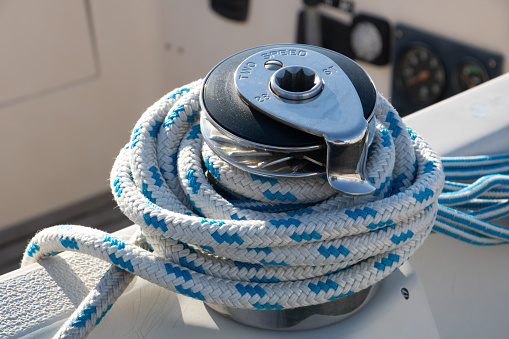 White and blue halyard on sailboat multi-speed manual winch
