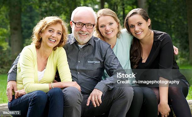 Padre Madre Y Dos Hijas Sonriendo Al Aire Libre Foto de stock y más banco de imágenes de 20 a 29 años - 20 a 29 años, Abrazar, Adulto