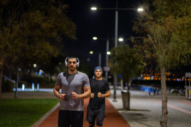 istock Two young athletes jogging at night. An impressive night light. 1862892576