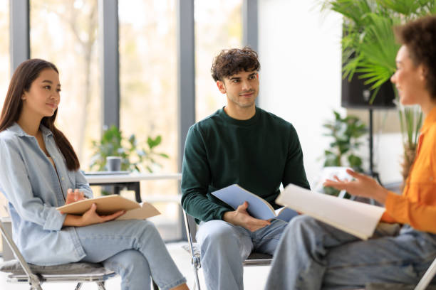 istock Happy international university students having a group discussion sitting together in circle of chairs and talking 1862897703