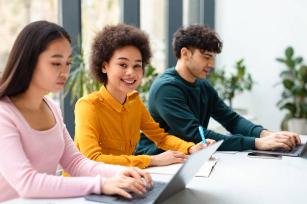 istock Happy black female student studying in classroom group, writing essay or preparing for test, groupmates sitting nearby 1862897741