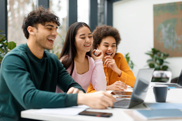 istock Happy three diverse friends studying together in coworking space, learning with laptop preparing for university exam 1862898248