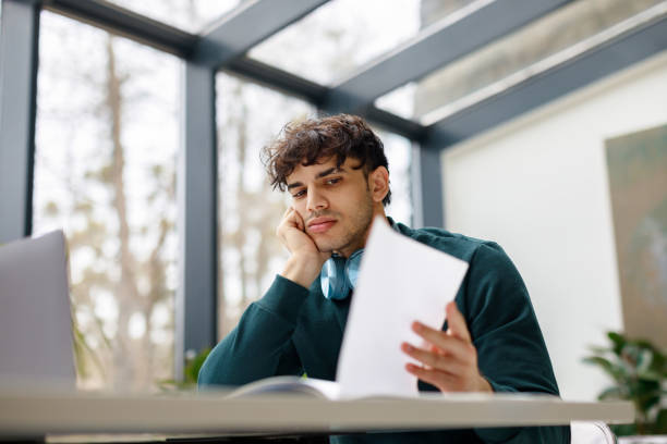 istock Portrait of bored european guy using laptop to write coursework paper, studying online, preparing for web exam 1862898792