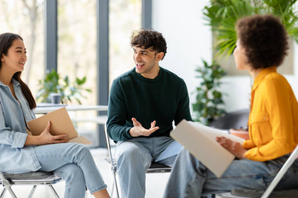 istock Three diverse enthusiastic friends classmates planning or discussing ideas, communicating in university audience 1862898800