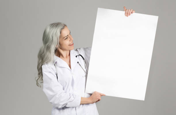 istock Lady Doctor Showing Blank Paper Poster Over Gray Studio Background 1862912823