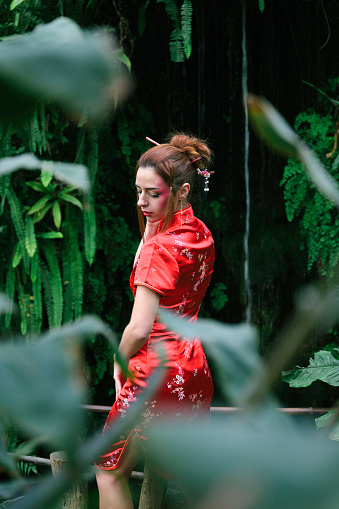 Experience the timeless beauty of a 25-year-old woman of European descent, captured in a series of vibrant portraits amidst a bamboo grove. Adorned in an elegant red Japanese dress, she embodies the harmony between Western culture and Japanese aesthetics. The warm hues of the kimono beautifully contrast against the lush green backdrop of bamboo, creating an enchanting atmosphere. Each shot reveals the model's natural grace, while the bamboo stalks provide a unique and soothing natural frame. Ideal for illustrating the fusion of fashion and nature, this portrait collection offers striking images for artistic, editorial, or advertising projects.