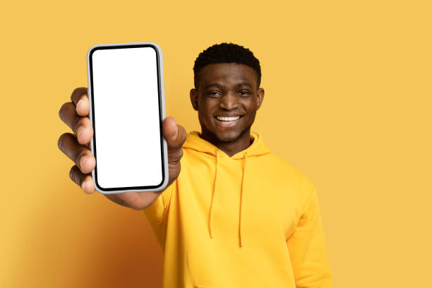 istock Cheerful young black guy showing big phone with blank screen 1862930172