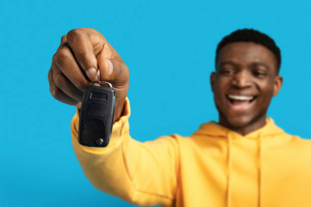 istock Automative car key in black man hand, blue background 1862930181