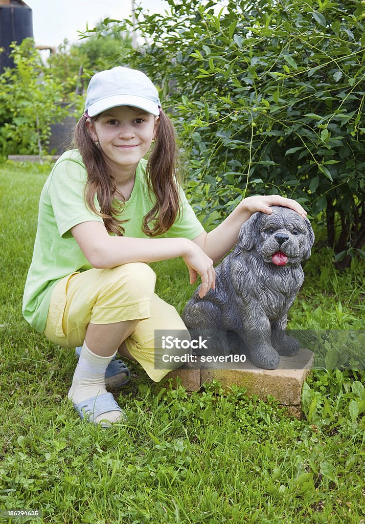 Souriant petite fille près de béton chien - Photo de Animaux de compagnie libre de droits