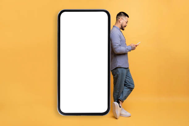 istock Asian Man Browsing Smartphone And Leaning At Big Blank Mobile Phone 1862958298
