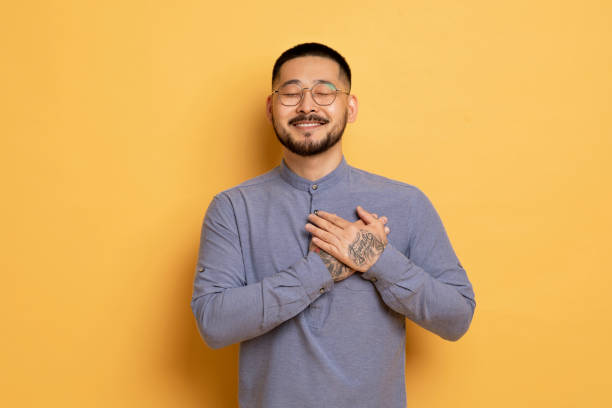 istock Gratitude Concept. Thankful Young Asian Man Keeping Both Palms On Chest 1862958330