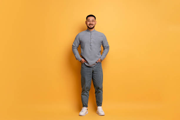 istock Smiling Young Asian Man Wearing Stylish Eyeglasses Posing Over Blue Studio Background 1862958352