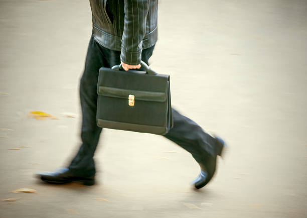 Image of a young Japanese businessman in Tokyo, walking the streets in the central area near Yoyogi station and Harajuku, checking smartphone apps. Business, salaryman concepts in Tokyo, Japan.