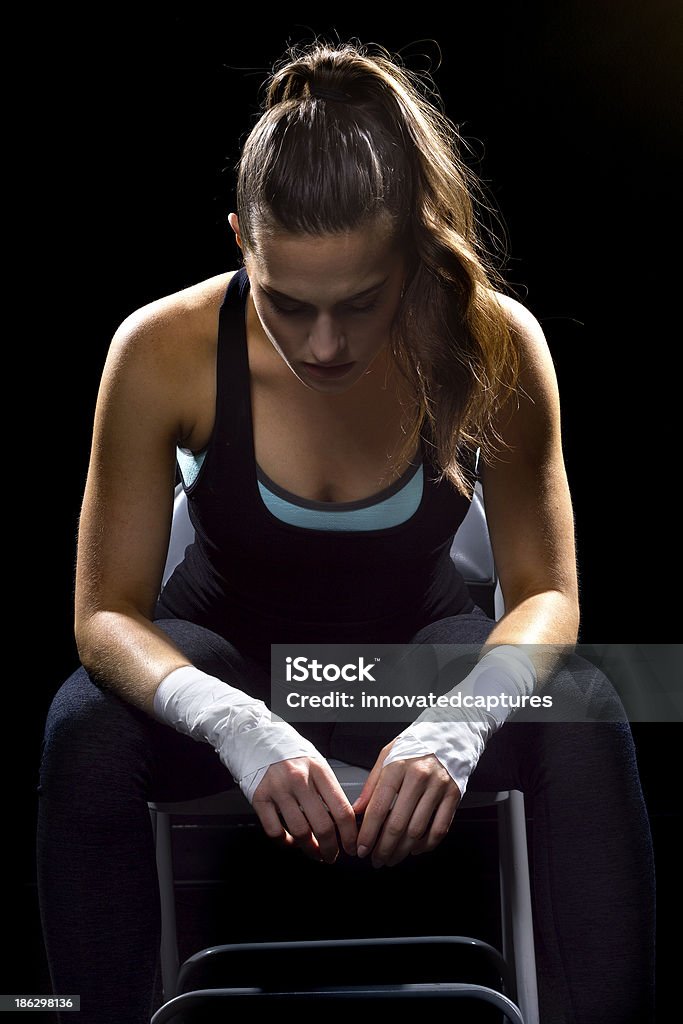 フィットに座る女性 MMA 格闘家、黒色の背景 - アクティブライフスタイルのロイヤリティフリーストックフォト