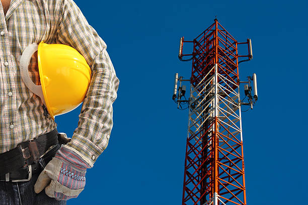 istock technician against telecommunication tower, painted white and re 186298644