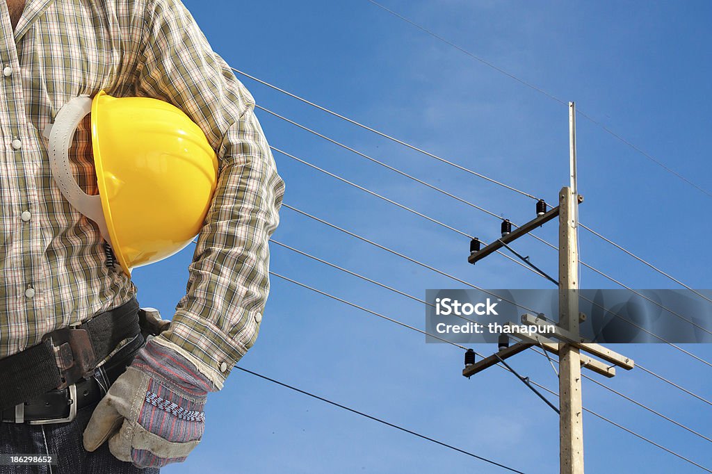 Eletricista Trabalhador a trabalhar contra pós e céu azul eléctrico - Royalty-free Adulto Foto de stock