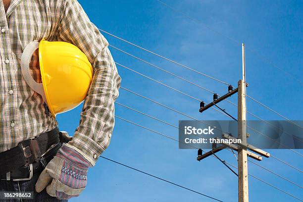 Eletricista Trabalhador A Trabalhar Contra Pós E Céu Azul Eléctrico - Fotografias de stock e mais imagens de Adulto