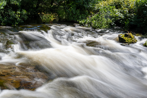 Long exposure of a waterfall on the East Lyn river flowing through the Doone Valley in Exmoor National Park