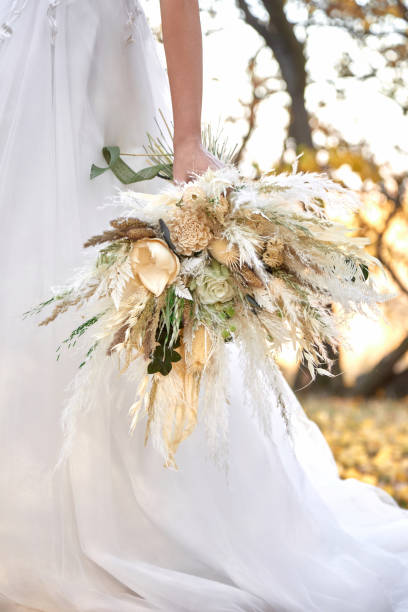 istock hands of the bride holding beautiful bouquet 1862990243