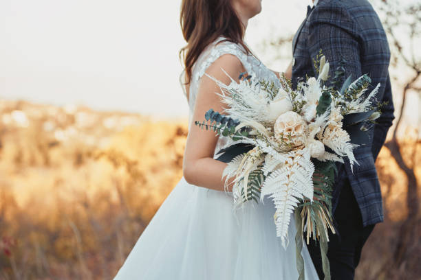 istock bride and groom holding a beautiful bouquet 1862990274
