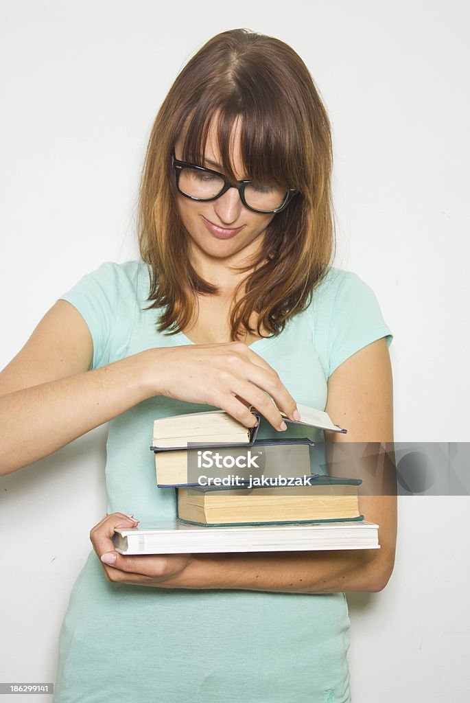 Giovane studentessa con libri su bianco. - Foto stock royalty-free di Abbigliamento casual