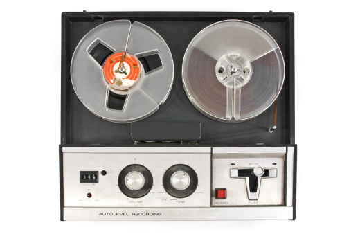 Old and obsolete reel tape recorder top view isolated on white background.