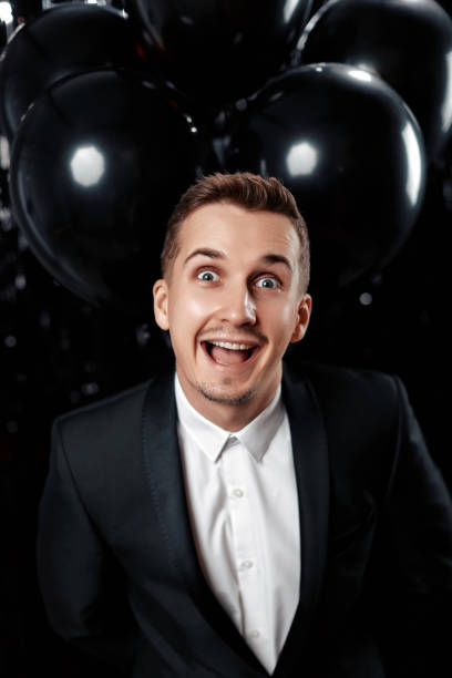istock e man in black jacket holding black air balloons 1863017494