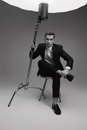 elegant model man in black suit in photostudio. black and white