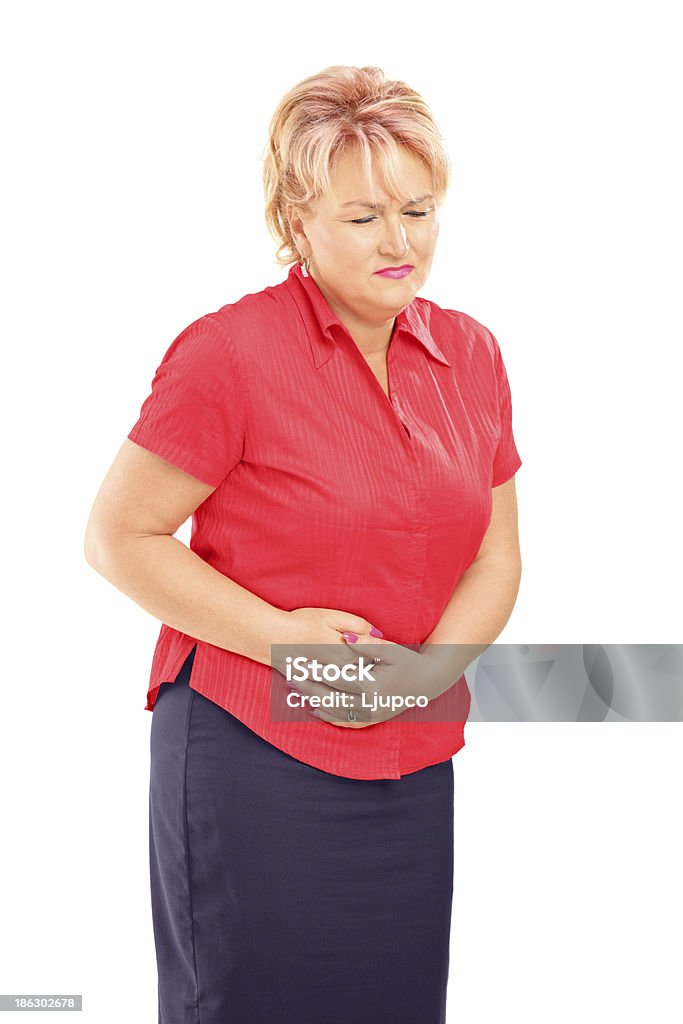 Mature blond female suffering from a stomach ache Mature blond female suffering from a stomach ache isolated on white background Ulcer Stock Photo