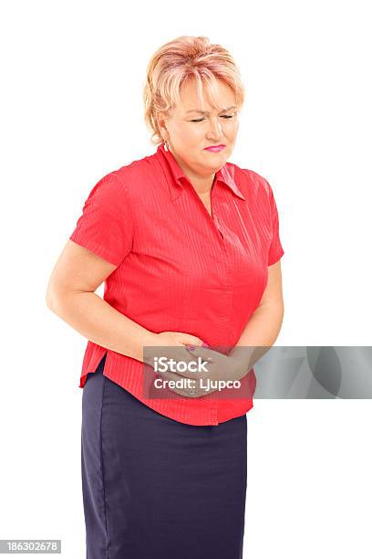 Mature Blond Female Suffering From A Stomach Ache Stock Photo - Download Image Now - Ulcer, Women, Adult